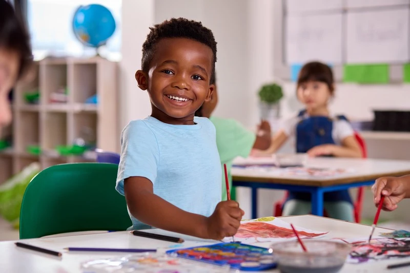 Classroom Portrait Of Smiling Male Elementary School Pupil In Art Class At School