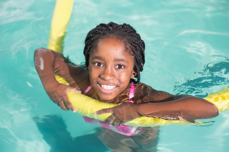 Cute little girl swimming in the pool at the leisure center
